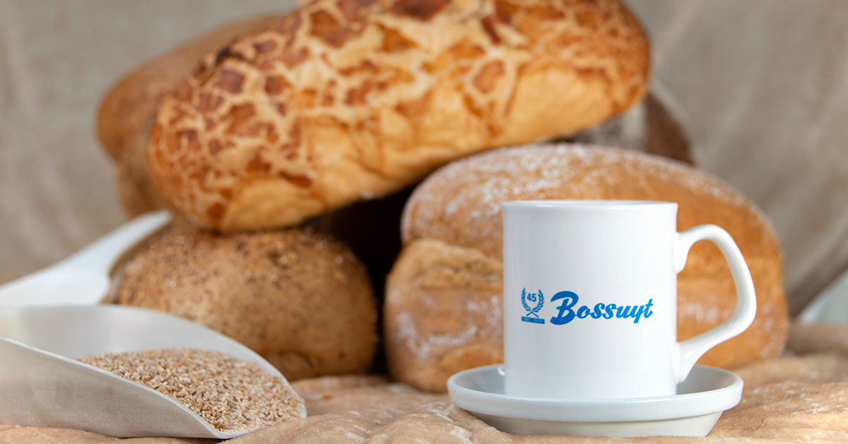 Tijgerbrood en grof brood naast een mok met het logo van Bossuyt